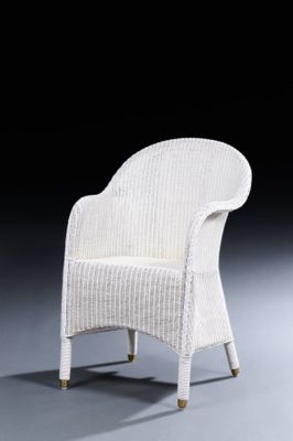 une chaise en osier blanche posée sur un sol gris, sur fond noir