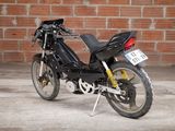 a black motorcycle parked in front of a brick wall