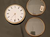 une horloge posée sur une table à côté d'un miroir