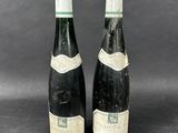 two bottles of wine sitting next to each other on a table