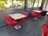 many red chairs and tables on the deck of a restaurant