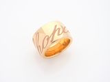 un gros plan d'une bague en or sur laquelle est gravé le mot « espoir »
