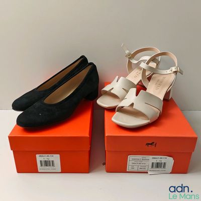 deux paires de chaussures noires et blanches posées sur des cartons orange