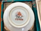 an open box with a white plate inside of it on a table