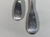 two spoons hanging from a hook on a wall