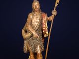 une statue en bronze représentant un homme tenant une lance et un bouclier