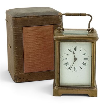 a small clock sitting next to a box on a white surface