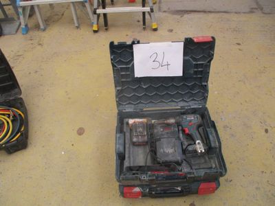 une boîte à outils contenant des outils, posée sur le sol