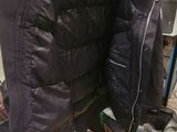 a jacket hanging on a clothes rack with a hat on top of it
