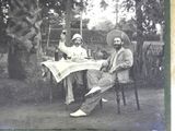 two men sitting at a table with drinks in their hands