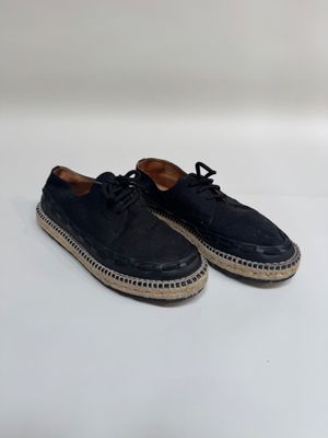 a pair of black sued shoes with laces on the sole
