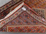 a close up of a rug on a floor with a red background