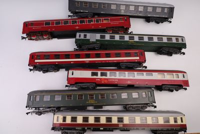 cinq trains posés sur une table blanche : un rouge, un vert et un noir