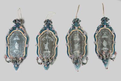 four pieces of glass hanging on a wall next to each other