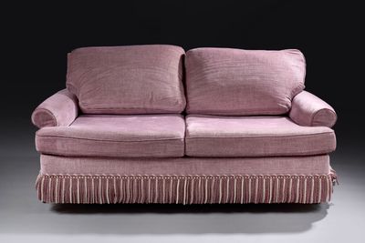 a pink couch that is sitting in a room