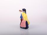 a figurine of a woman in a yellow dress