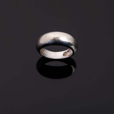 gros plan d'une bague en argent sur une surface noire