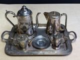 a silver tray with a silver tea set on it