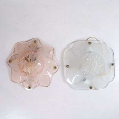 deux morceaux de verre posés sur une surface blanche : l'un est rose et l'autre est transparent