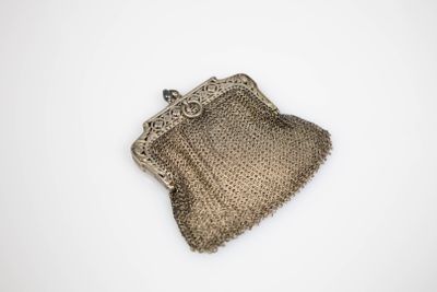 an antique silver mesh purse on a white background