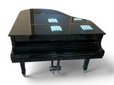 a black piano that is sitting on a white surface