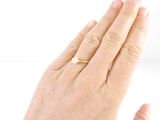 a woman ' s hand with a gold ring on it