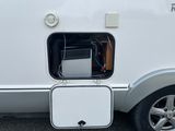 an image of a small white rv with a box attached to the side of it