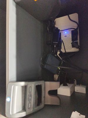 un ordinateur et d'autres appareils électroniques posés sur une étagère dans une pièce