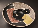 a black and white bowl with a woman ' s face painted on it