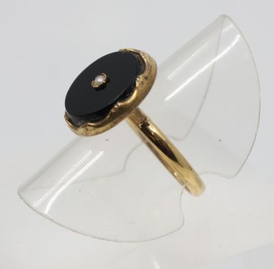 Gros plan sur une bague en or ornée d'une pierre noire