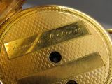 a close up of a gold pocket watch on a table