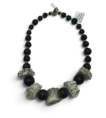 un gros plan sur un collier composé de perles noires et blanches