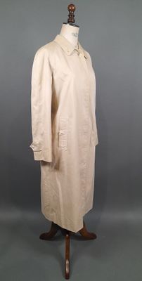 une blouse blanche posée sur un mannequin, sur fond gris