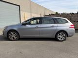 the silver car is parked in the parking lot near a building