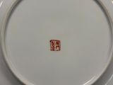 une assiette blanche sur laquelle est apposé un tampon rouge