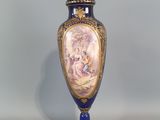 un vase bleu et or sur lequel est représentée une femme