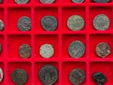 a red display case with a lot of coins in it