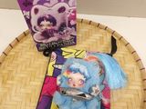 a small doll sitting on top of a tray next to a box