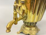 a gold vase with a brass handle on a table
