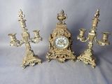 trois bougies et une horloge posées sur une table