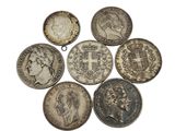 six different british coins are arranged in a circle on a white surface
