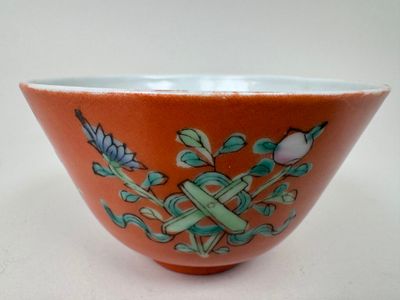 un bol orange orné de motifs bleus et blancs