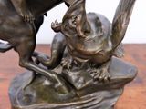 bronze statue of a boy on a horse and a dog on a rock