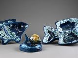 two blue fish figurines sitting next to each other on a table