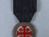 a close up of a medal with a red cross on it