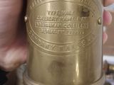 a person holding a brass oil burner in their hand