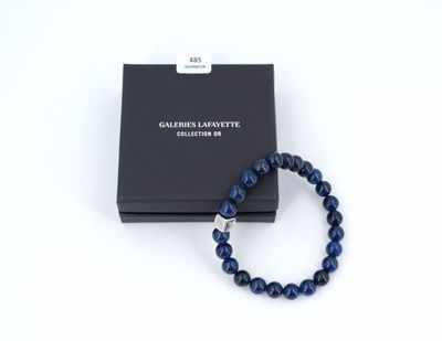 a bracelet with a black box and a blue beaded bracelet
