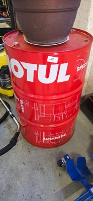 a red barrel with a brown pot sitting on top of it