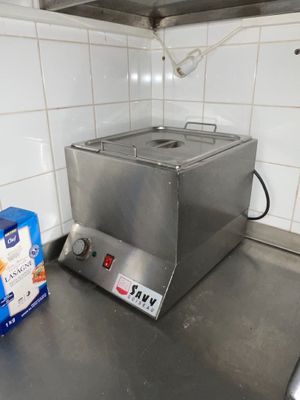 stainless steel counter top in a commercial kitchen with a fryer on it