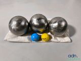 trois balles sont posées sur un tissu posé sur une table